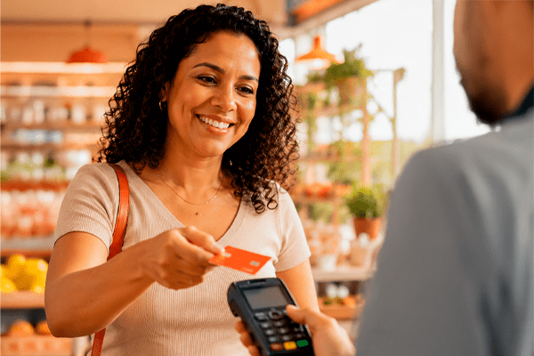 Mulher usando ticket alimentação CCT Sintibref-DF